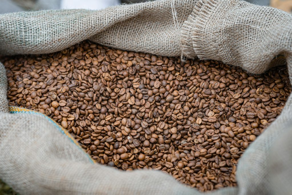 A close-up of freshly roasted coffee beans in a burlap sack, perfect for coffee lovers.